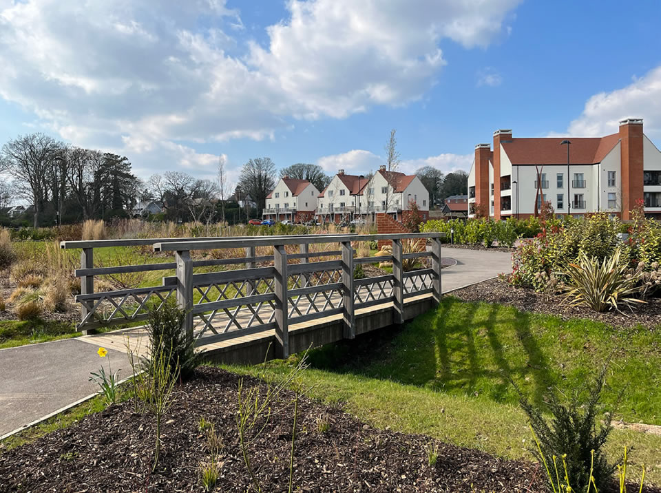 A bridge facilitating access over a planted swale that has been successfully integrated into a local open space.