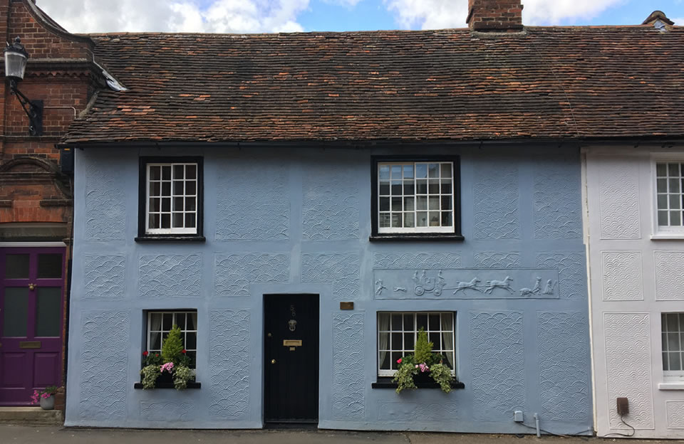 Traditional pargetting on Gold Street with colourful palette.