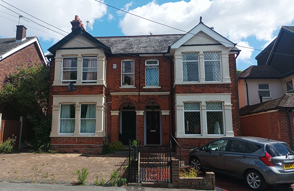 Edwardian paired semi-detached houses with red brick and arched doorways on Station Road.