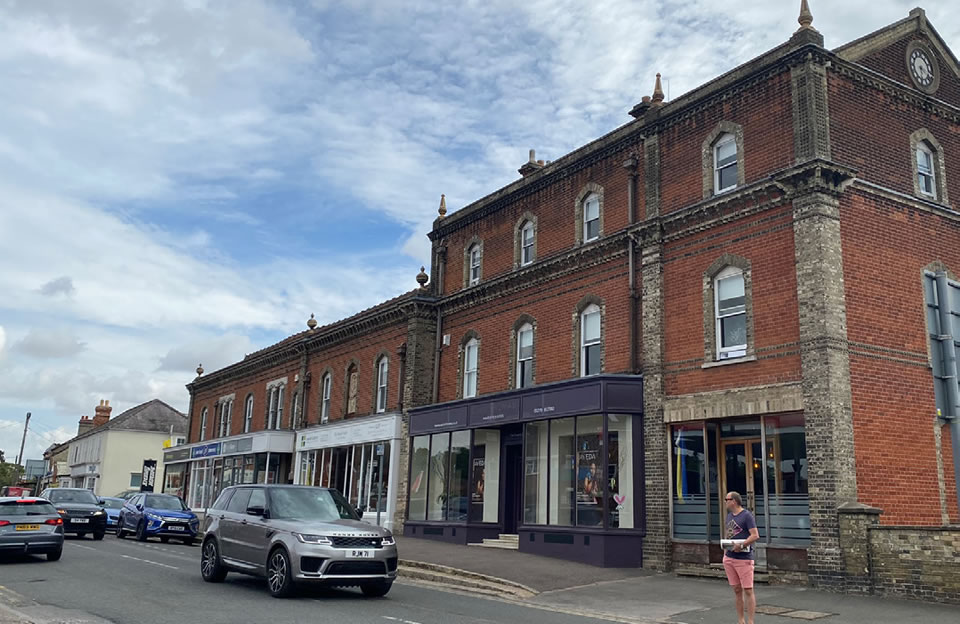 Historic red brick with eave detailing integrating Cambridge Road shops.