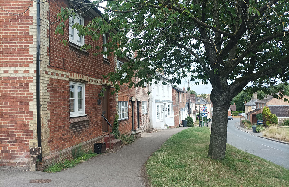 Red brick terraces with barn doors opening onto Wicken Road, Newport.