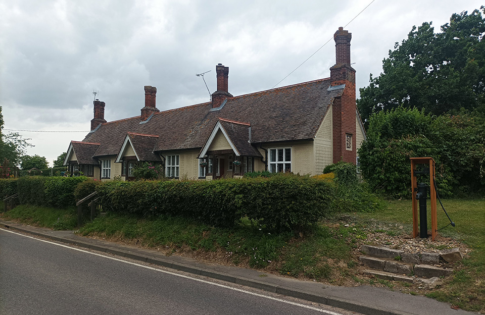 Almshouses in Radwinter - Three gabled porches project on the front. Roofs tiled, with 4 chimney stacks each and casement windows.