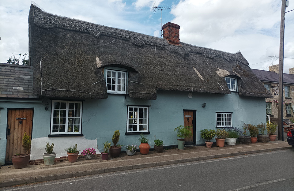 Thatched roof with pargetting and Almshouse massing along B1053, Great Sampford.