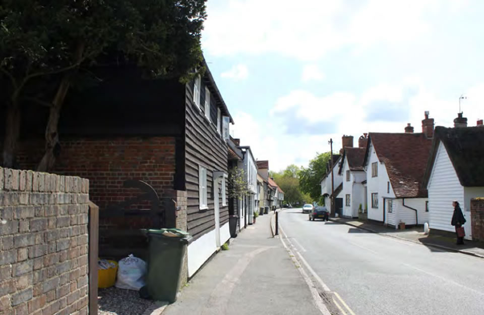 Curved street and weatherboarding creates horizontal desire lines through The Street, Manuden.