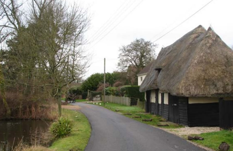 Farm complex bisected by the lane in Baconend.