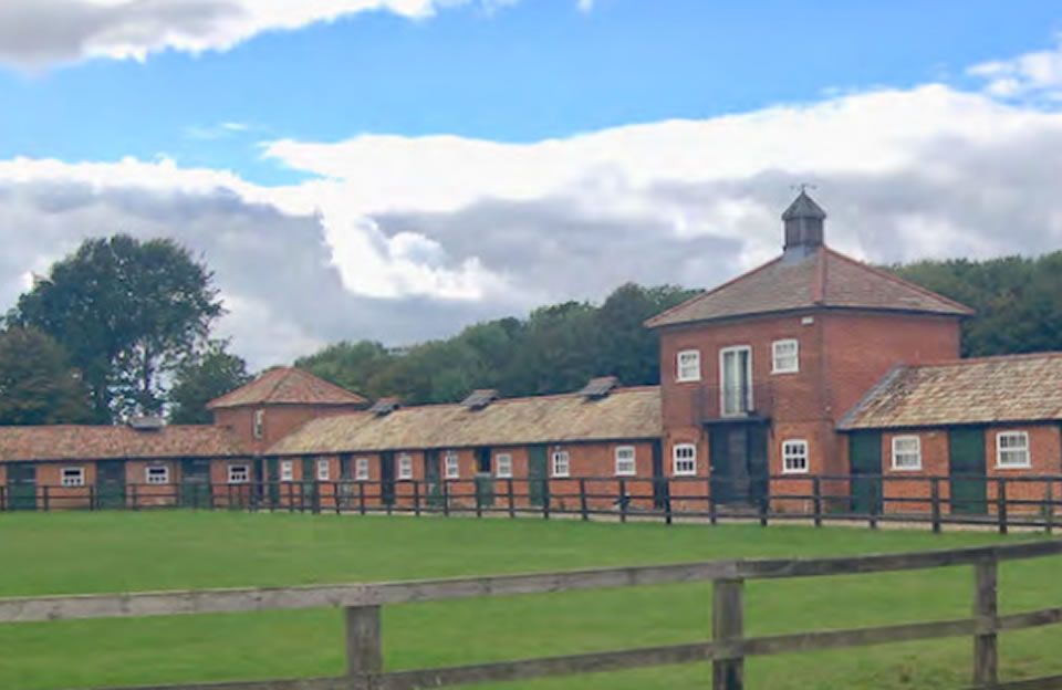 Individual single-storey stables at Brookend Farm Stables. Central two-storey block - built with red brick, projecting wings and gabled tile roof.