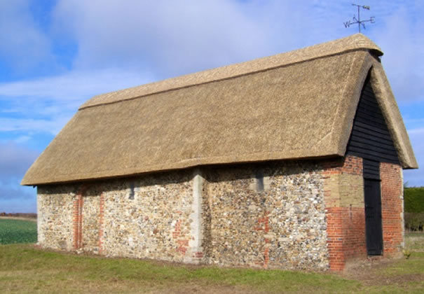 Brick-and-flint building with weatherboarding and thatched roof in Wicken Bonhunt.